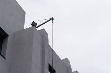 İnşaat malzemelerini kaldırmak için evin çatısında elektrikli bir vinç var.