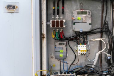 Endüstriyel bir ortamda çeşitli kablolar, devreler ve bileşenler içeren karmaşık bir elektrik kontrol paneline ayrıntılı bir bakış