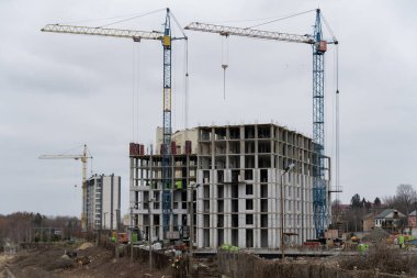 Bir ev inşaatı, zemin inşa süreci, inşaat arka planında vinçler.