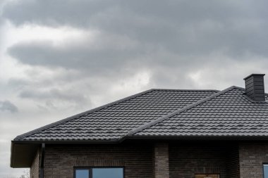 Klasik siyah metal kiremit çatı kaplaması, modern yüzle uyumlu.