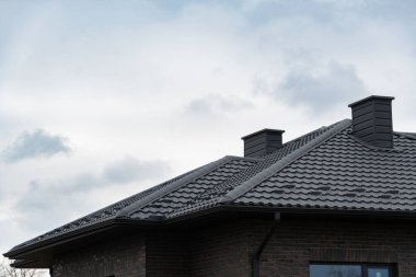 İki bacası olan modern metal profilli bir çatı.