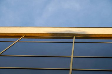 Günışığı, öğleden sonra saatlerinde mimari çizgileri vurgulayarak çağdaş bir binanın cam cephesine yansıyor.