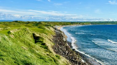Uçsuz bucaksız okyanusu görkemli bir şekilde gören nefes kesici bir uçurum. Kayalıkların altındaki çimenli güzel bir tepe ile birleştirilmiş.