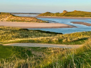 Bereketli yeşil çimenler ve yumuşak, ılık kumlarla çevrili engin bir su genişliği huzurlu bir doğal manzara yaratıyor.