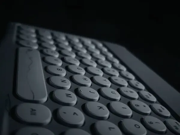 Yuvarlak tuşlu siyah beyaz bir klavyenin yakın çekimi. Anahtarlar standart QWERTY düzeninde düzenlenmiştir. 