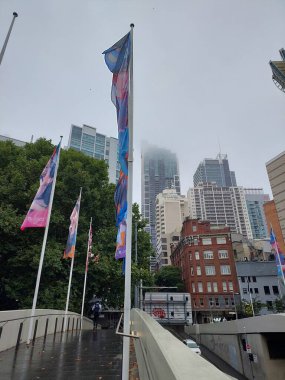 Sydney, Avustralya - Jan 2023, 4: Renkli bayraklı bir yaya köprüsü bulutlu bir günde hareketli bir şehir caddesine bakıyor.
