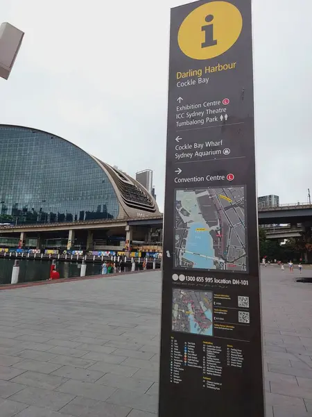 Etkileyici ICC Sydney 'nin önünde, canlı Darling Harbour bölgesinde ziyaretçilere rehberlik eden yararlı bir bilgi direği duruyor. İşaretin ayrıntılı haritası popüler çekimleri gösteriyor 