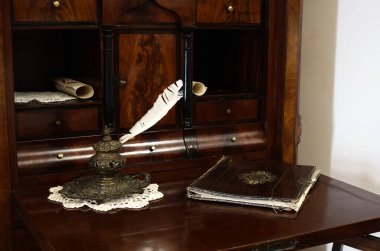 Tüy kalem ve günlükle dolu bir masa.