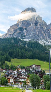 Dolomites, İtalya 'da yaz aylarında arka planında kayalık dağ olan Corvara köyü.