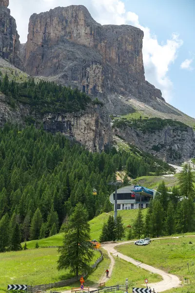 Dolomitler, İtalyan---28 Temmuz 2024: Yazın güzel çayır, orman ve kaya zirvesindeki teleferik istasyonu