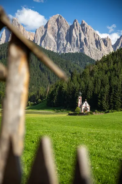 Yazın St. John Kilisesi 'nin arka planında sallantılı bir dağ olan Dolomitler, İtalya