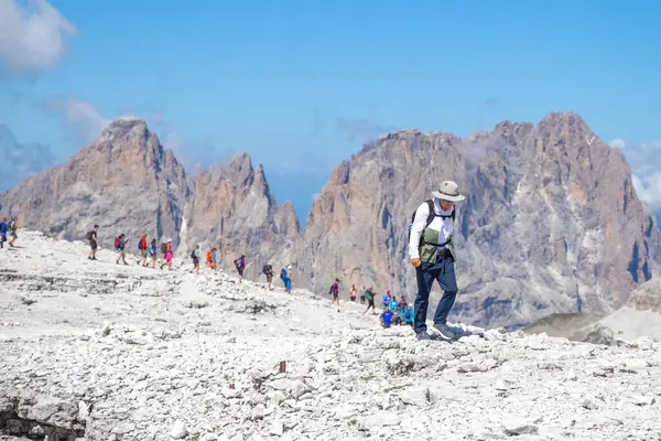 Dolomitler, İtalyan---29 Temmuz 2024: Funivia Sass Pordoi 'de kayalık dağın tepesinde yürüyen yaşlı bir beyaz adam, yüzey gibi ay