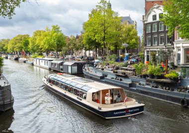 Amsterdam, Hollanda-22 Eylül 2023: Kanalda turistlerin sürdüğü bir kanal gezisi