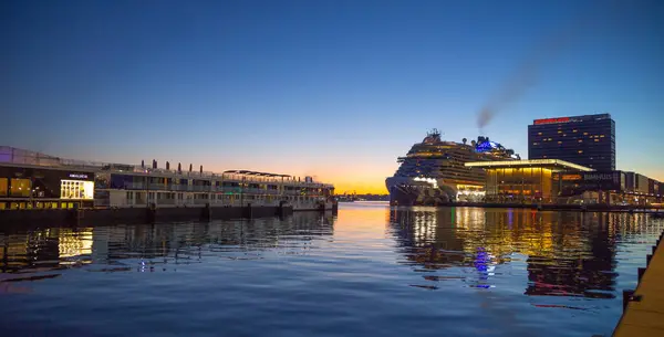 Amsterdam, Hollanda Ekim 05, 2024: Norveç 'in şafak vakti Amsterdam Limanı' ndaki Prima Cruise parkı, nehirdeki yansıması