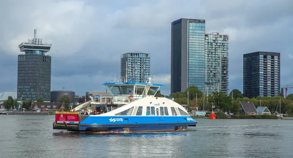 Amsterdam, Hollanda-Sep 22, 2023: IJ nehrinde arka planda gökdelenler olan bir feribot.