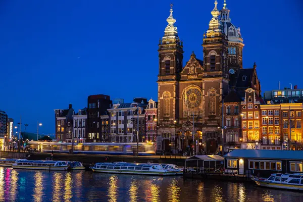Hollanda, Amsterdam 'da gece vakti kanal gezisi yapan Aziz Niklas Bazilikası