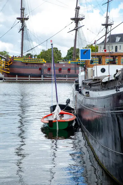 Amsterdam 'da büyük bir geminin yanında filikalar bağlı.