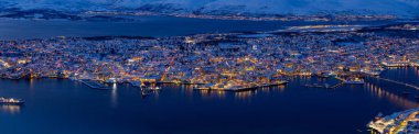 Trom 'un mavi saatindeki panoramik hava manzarası. Etrafı koyu mavi deniz Utsiktspunkt, Norveç ile çevrili güzel sarı ışıklar.