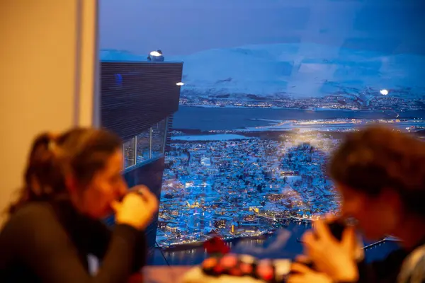 Troms, Norveç, 10 Ocak 2025: Utsiktspunkt 'taki Fjellstua Cafe Og Restoranı' nda kahve içen turistler, kutup gece görüşü.