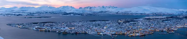 Trom 'un mavi saatindeki panoramik hava manzarası. Kar dağı ve pembe gökyüzü, Utsiktspunkt, Norveç.