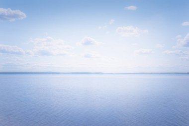 Finlandiya 'dan mavi gökyüzü ile güneşli yaz gölü manzarası.