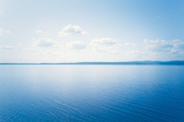 Finlandiya 'dan mavi gökyüzü ile güneşli yaz gölü manzarası.