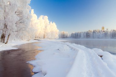 Soğuk kış günbatımı nehir manzarası. Karlı ağaçlarla dolu. Fotoğraf: Kuhmo Finland