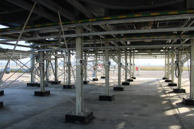 Metal kirişlerden, destek sütunlarından ve güçlendirilmiş temellerden oluşan bir endüstriyel yapı. Gaz kompresör istasyonu altyapısı.