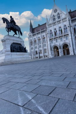 Budapeşte, Macaristan - 02 Mayıs 2025: Macar Parlamento Binası 'nın ön planda Ferenc Rkczi 2 heykeli ile dramatik bir alçak açı çekimi.