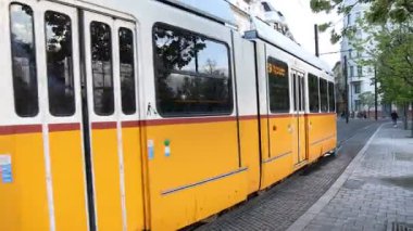 Budapeşte, Macaristan - 2 Mayıs 2025: Tarihi bir Avrupa şehrinin kaldırım taşı sokakları boyunca etkileyici bir klasik tramvay süzülüyor, klasik tasarımı ve kendine özgü tramvayı nostalji ve eski dünya cazibesini çağrıştırıyor.. 