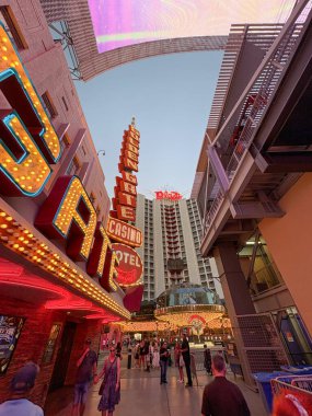 Las Vegas, USA - August 24, 2025: Vibrant street scene showcasing glowing neon signs, casino lights, and the famous Fremont Street atmosphere with people walking beneath the illuminated displays.