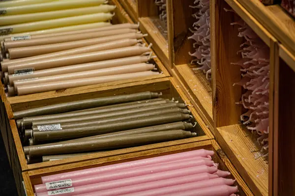 Pastel mumlar bir mağazanın rafındaki tahta kutularda.