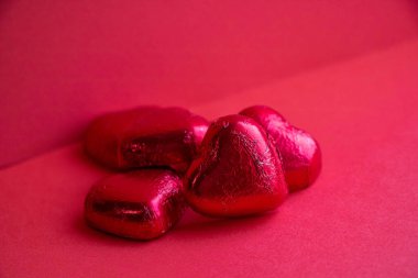 Kırmızı arka planda bir yığın çikolata. Sevgililer Günü konsepti