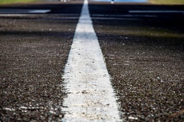 Close-up shot of a strip of white textured road markings clipart