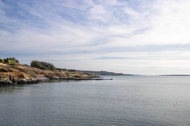Sol tarafındaki kayalık plajlı mükemmel deniz manzarası ve İrlanda 'nın sağ tarafındaki sakin su.