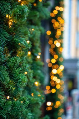 Ön planda ışıklandırma ve bulanık arka planda Noel çelengi dalları