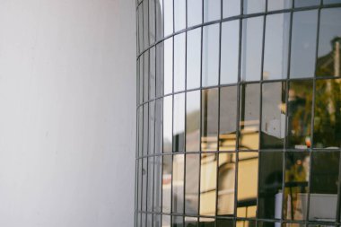 Sağ taraftaki küçük dikdörtgen camlardan ve sol taraftaki boş duvarlardan oluşan göz kamaştırıcı bir pencere.