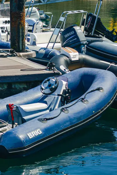 Mavi şişme bot dikey açıyla rıhtımda duruyor.  