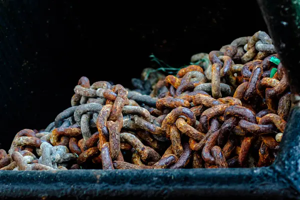 Koyu bir kabın içindeki paslı zincir, deniz suyuyla paslanmış.