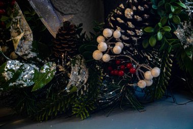 Beyaz ve kırmızı plastik böğürtlenli karlı bir Noel çelengi.