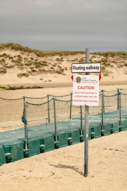 İrlanda 'daki Barley Cove Sahili' nin yanındaki kaldırımda uyarı levhası.
