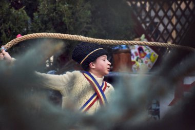 Romanya, Aralık 2023: Ayı kürkü ve Romen gelenekleri giymiş bir adam, her yıl sonunda düzenlenen 