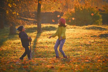 Parkta oynayan çocuklarla sonbahar manzarası