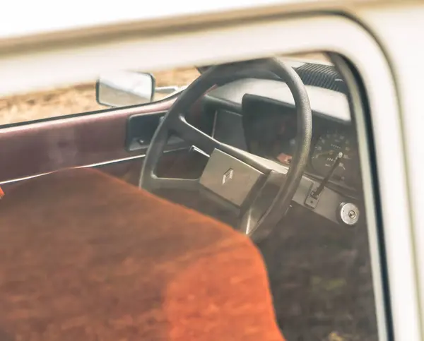 Kahverengi koltuklu ve direksiyonlu klasik otomotiv tasarımının özünü yakalayan klasik bir arabanın içi. İç mekanın basitliği ve kırsal çekiciliği vurgulanıyor..