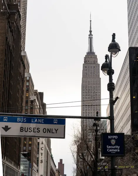 Arka planda Empire State Binası 'nın belirgin bir manzarası olan bir şehir sokak sahnesi, şehir altyapısını ve tabelalarını gözler önüne seriyor..