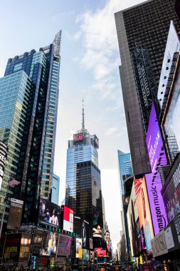 Görüntü, yüksek gökdelenleri ve renkli dijital reklam panoları ile kentsel faaliyetlerin kalbini yakalayan canlı şehir yaşamını gözler önüne seriyor. Sahne, modern mimari ve canlı sokak kültürünün bir karışımını gösteriyor..