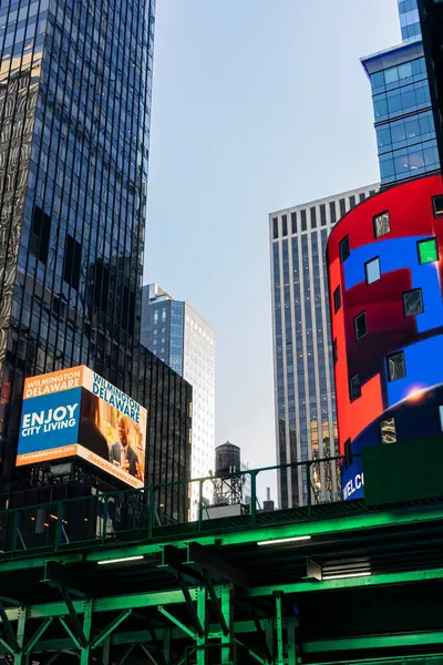 Canlı bir şehir manzarası modern gökdelenler ve hareketli bir şehir ortamında göz alıcı reklam panolarının karışımı..