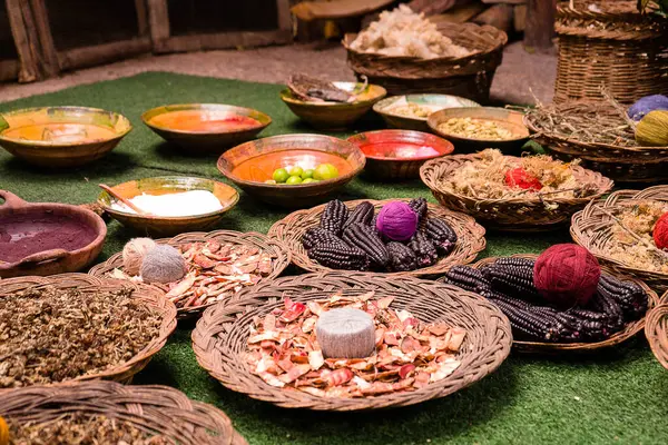 Geleneksel tekstil üretiminde kullanılan iplikler, tohumlar ve bitki bazlı malzemeler de dahil olmak üzere doğal malzemeler ve boyalar renkli bir düzenleme..