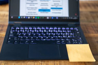 Klavyesinde sarı bir yazı olan bir laptop. Posta, bir şeyler yapmamız gerektiğini hatırlatıyor.