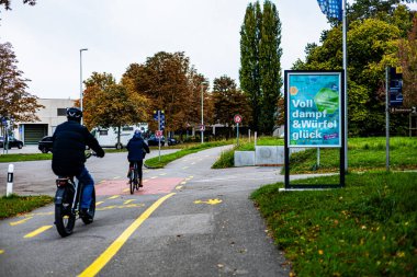 İşe bisikletle giden ya da egzersiz yapan iki kişi.